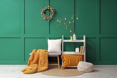 Şenlik salonundaki raflarda ağaç dalları ve Paskalya yumurtaları olan vazo.