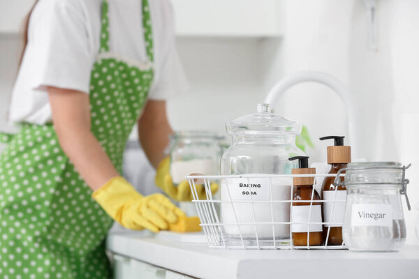 Basket with natural cleaning supplies on counter in kitchen, closeup