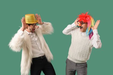 Yeşil arka planda suratını buruşturan komik görünümlü iş adamları. 1 Nisan Kutlaması