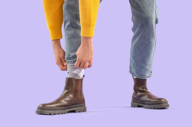 Leylak geçmişi olan çizmeli genç bir adam.