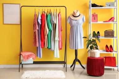 Manken, giysi askılığı ve raf ünitesi olan soyunma odasının içinde.