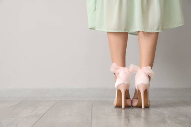 Aydınlık duvarın yanında güzel topuklu bir kadın