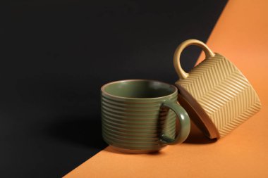 Renk arkaplanında farklı seramik bardaklar