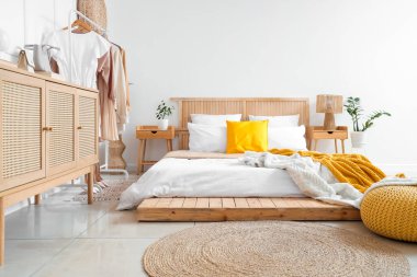 Modern konforlu yatak odası ve kadın giysileriyle dolu raflar.