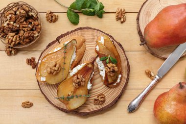 Ahşap zemin üzerinde ricotta peynirli ve cevizli armut bruschetta.