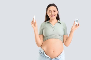 Glukometresi ve arka planda tükenmez kalemi olan hamile bir kadın. Gebelik Diyabet Konsepti