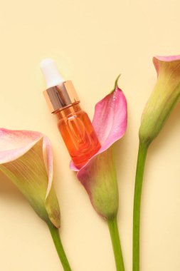 Bir şişe gerekli yağ ve arka planda güzel zambaklar