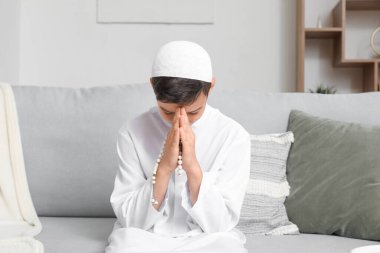 Little Muslim boy praying at home