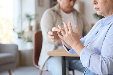 Boşanma avukatının ofisinde evlilik yüzüğünü parmağından çıkaran olgun bir kadın.