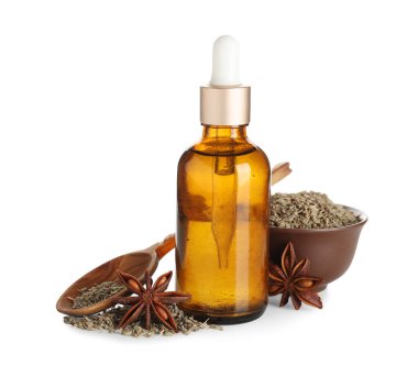 Bir şişe gerekli yağ, kurutulmuş tohumlarla dolu kase, anason yıldızları ve beyaz arka planda tahta kaşık.