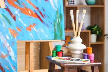 Resim malzemelerinin olduğu tabure atölyede resim sehpasının yanında.