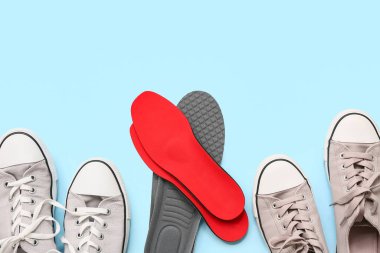 Açık mavi zemin üzerinde ortopedik tabanlı ayakkabılar