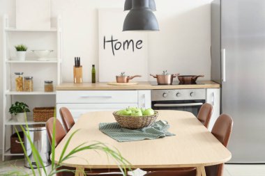 Mutfaktaki yemek masasında elmalı hasır kase.