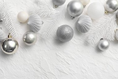 Beyaz grunge arka planında köknar dalları olan gümüş Noel mücevherleri