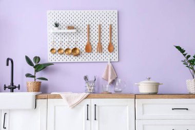 Tahtası, lavabosu ve beyaz tezgahı olan şık bir mutfak.