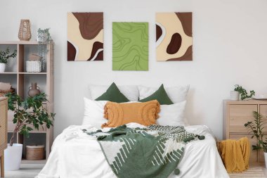 Şık yatak odaları, rahat yataklar, ev bitkileri ve güzel tablolar.