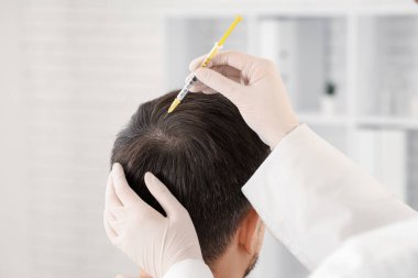 Trikoloğum klinikte saç büyümesi için iğne yapıyor.