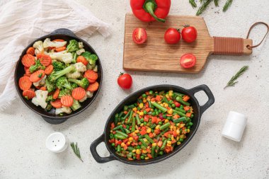 Beyaz grunge arka planda lezzetli kızarmış sebzeli kızartma tavaları.