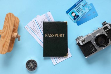 Pasaport, bilet, fotoğraf makinesi, ehliyet ve kredi kartı içeren kompozisyon
