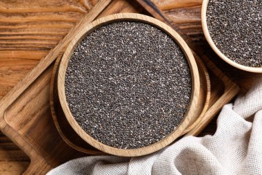 Ahşap arka planda chia tohumları olan bir kase, yakın plan.