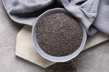 Gri grunge arka planında chia tohumları olan bir kase