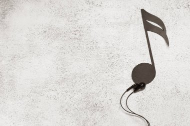 Kulaklıklı kompozisyon ve beyaz grunge arkaplan üzerine kağıt nota