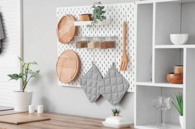 Mutfakta beyaz duvarın yanında beyaz tezgah ve raf ünitesi var.