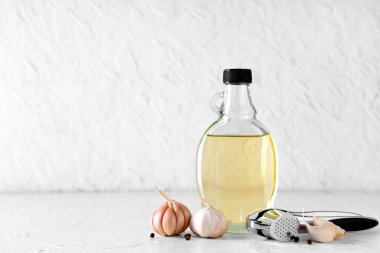 Beyaz arka planda biberli bir şişe taze sarımsak yağı.