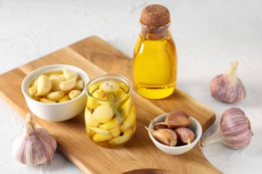 Beyaz arka planda bir şişe taze sarımsak yağı.