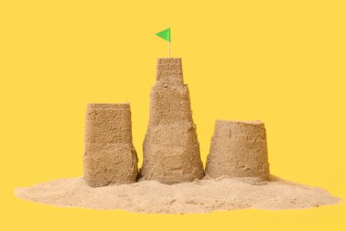 Sarı arka planda bayrağı olan güzel kumdan kale