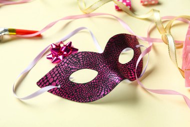 Güzel bir karnaval maskesi ve bej arka planda parti düdüğü