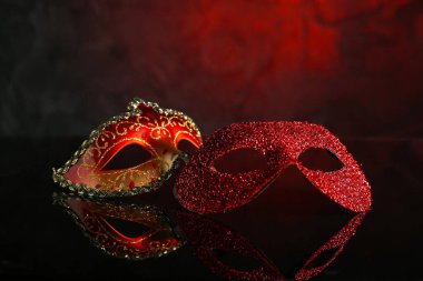Koyu kırmızı arka planda farklı güzel karnaval maskeleri.