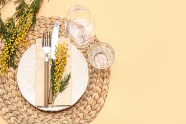 Turuncu arka planda mimoza çiçekleri olan güzel bir masa.