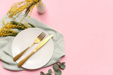 Mimoza çiçekleri ve pembe arka planda okaliptüs olan güzel bir masa.