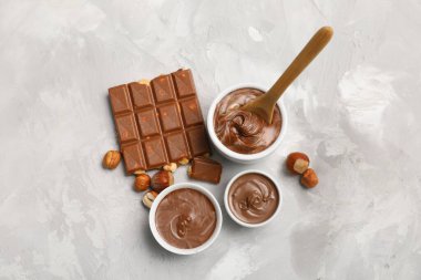 Tatlı çikolata kâseleri ve fındıklar gri arka planda