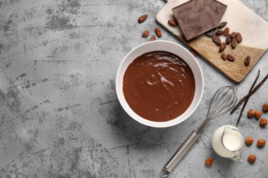 Lezzetli sıcak çikolatalı kase, çırpılmış çırpılmış süt ve grunge grisi arka planda kavanoz. Üst görünüm