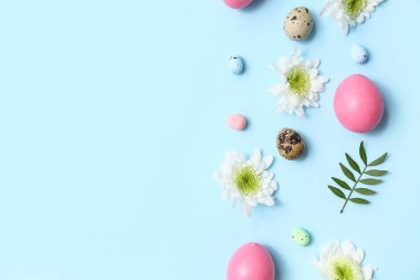 Çiçekli kompozisyon ve mavi arka planda Paskalya yumurtaları
