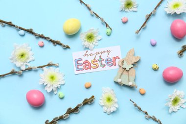 Easter postcard with eggs, flowers and pussy willow branches on blue background