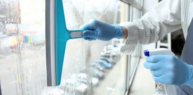 Odadaki pencereyi temizleyen adam, yakın plan.