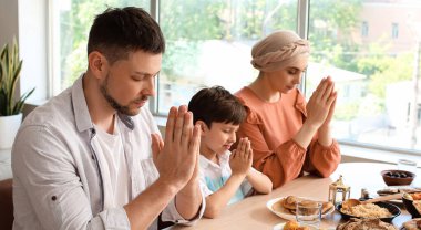 Müslüman aile yemekten önce birlikte dua ediyor. Ramazan kutlaması