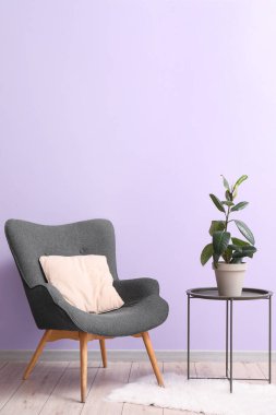 Koltuk, masa ve leylak duvarın yanındaki çiçek.