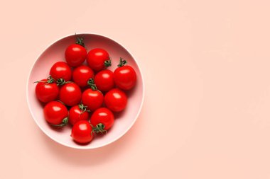 Pembe arka planda taze kiraz domatesli kase.
