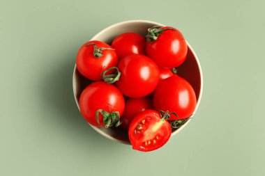 Gri arka planda taze vişne domatesli kase
