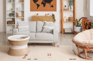 Beyaz duvarda kanepe, masa ve dünya haritası olan oturma odasının içinde.