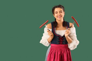 Yeşil arka planda sosisleri olan genç Ekim Festivali garsonu.