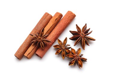 Beyaz zemin üzerinde tarçın çubukları olan yıldız anason, üst görünüm