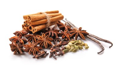 Tarçın çubuklu yıldız anason, karanfil, kakule tohumu ve beyaz arka planda vanilya kabuğu