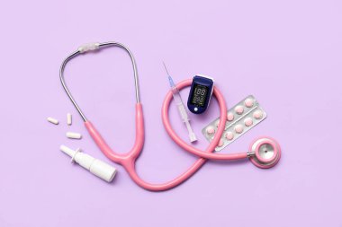 Leylak arka planında nabız oksimetresi, steteskop, şırınga ve ilaçla bileşim