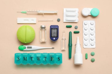 Bej arka planda nabız oksimetresi, termometre ve ilaçlarla bileşim