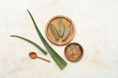 Ahşap tepsi ve kase beyaz grunge arka planda taze aloe vera yaprakları